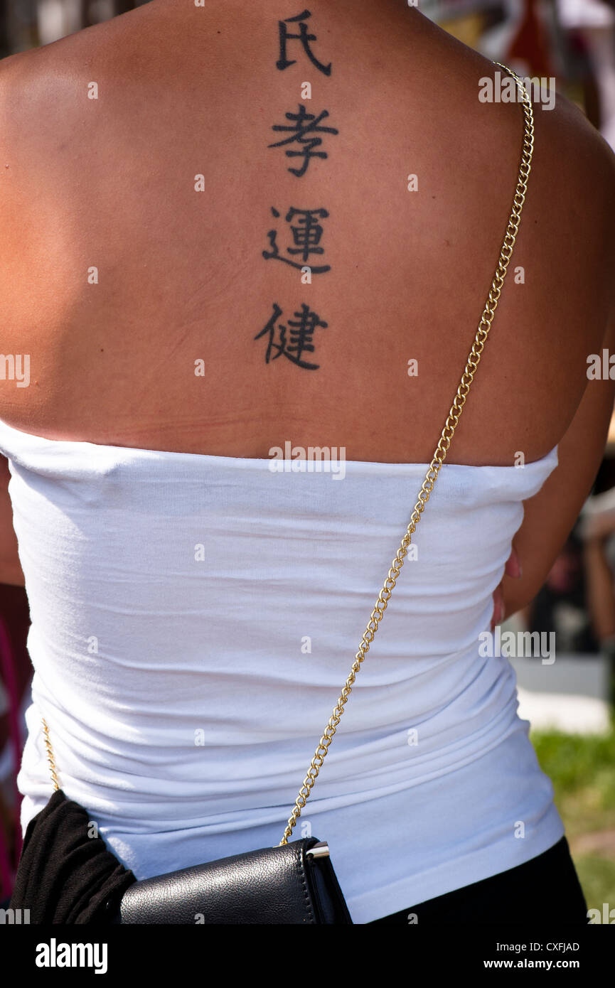 Tattoo of Chinese characters on a western woman's back Stock Photo - Alamy