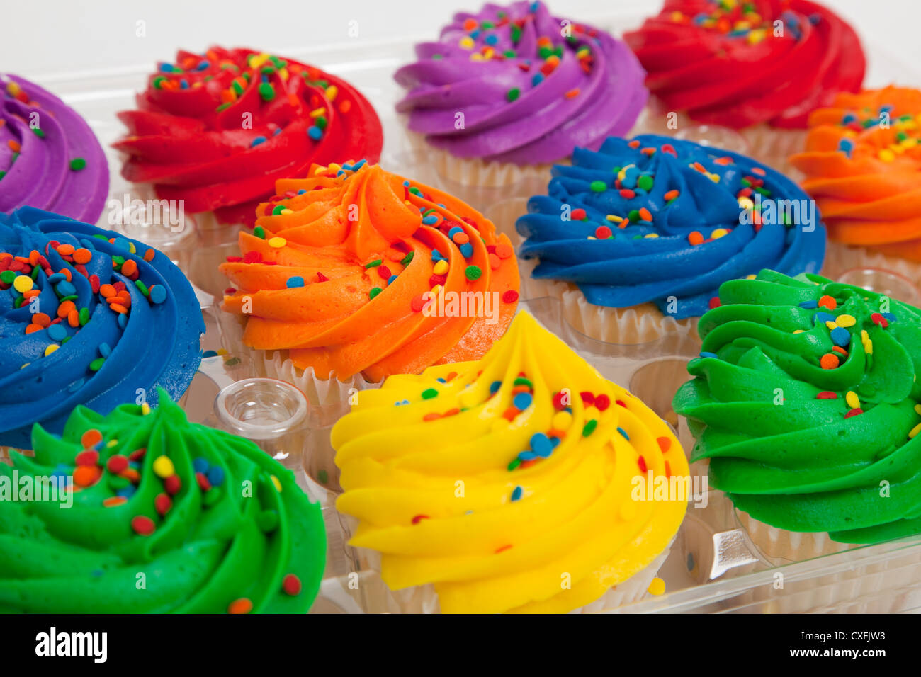 Assorted colored frosted cupcakes in a container Stock Photo Alamy
