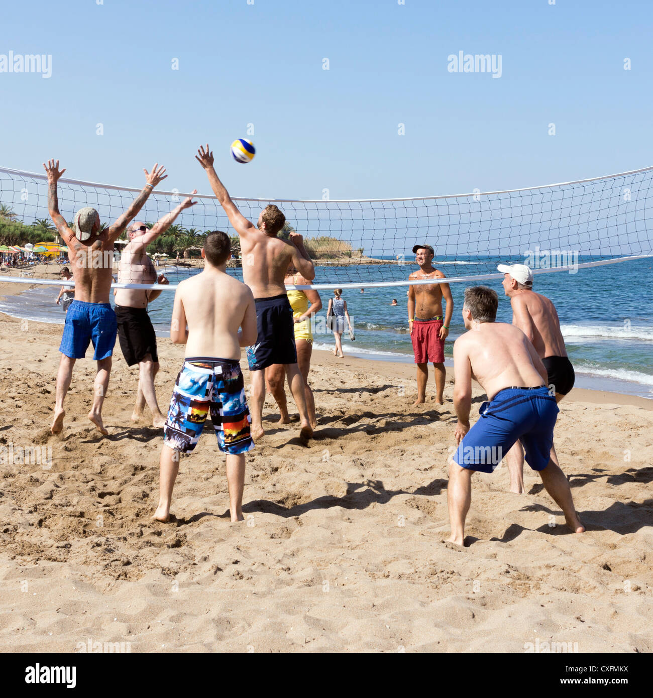 A mixed sex game of beach, or sand, volley ball, Crete Greece Stock Photo