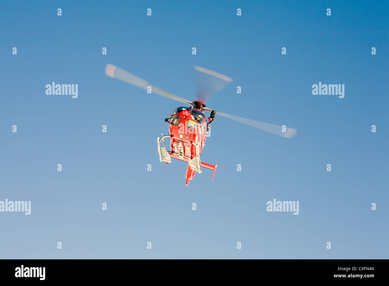 Air Ambulance attending a serious skiing accident on a piste in Selva Val Gardena Dolomites Italy. Helicopter type EC 135 Stock Photo