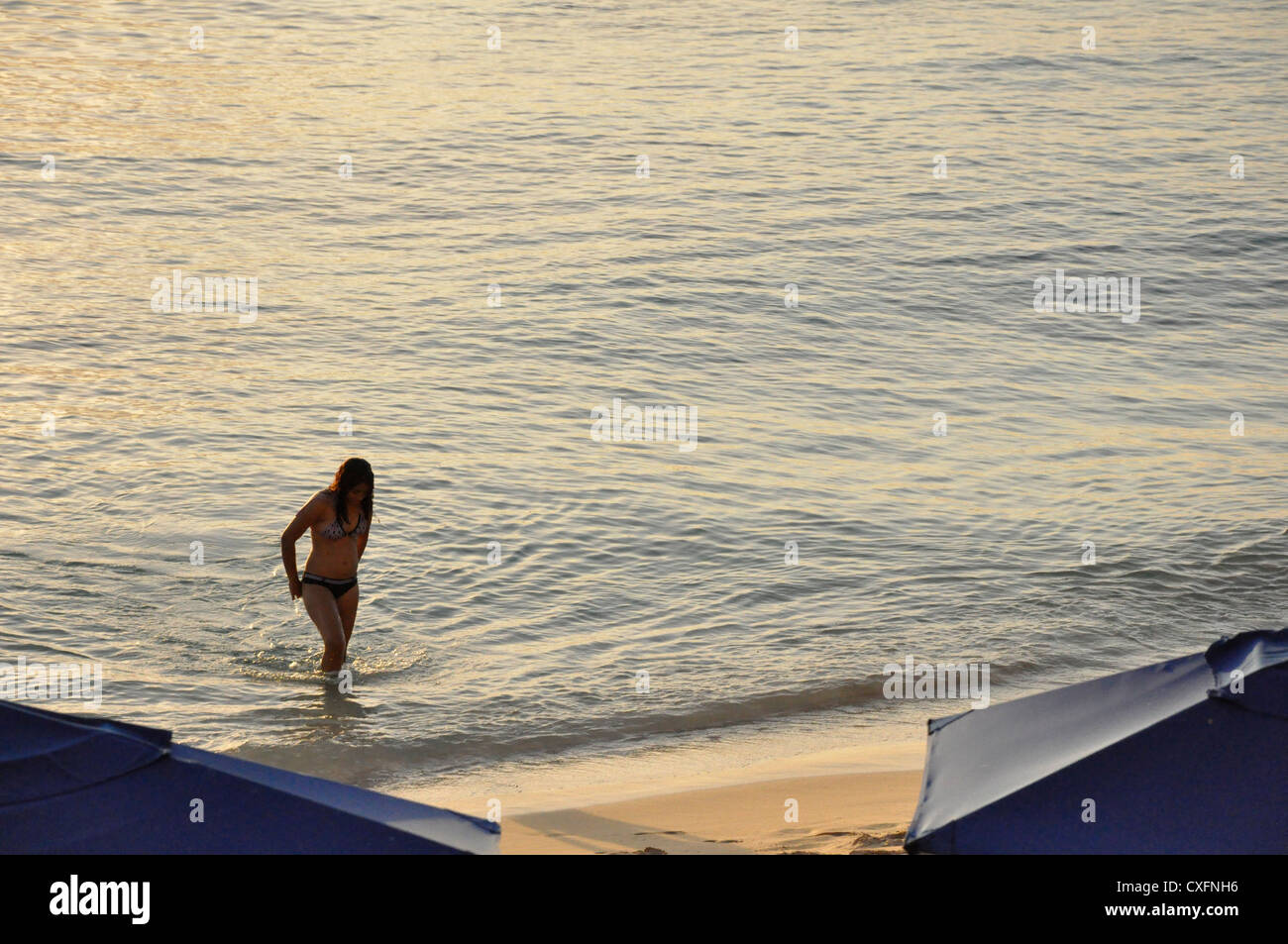 female bather in silhouette Stepping out of the sea Barbados Stock Photo