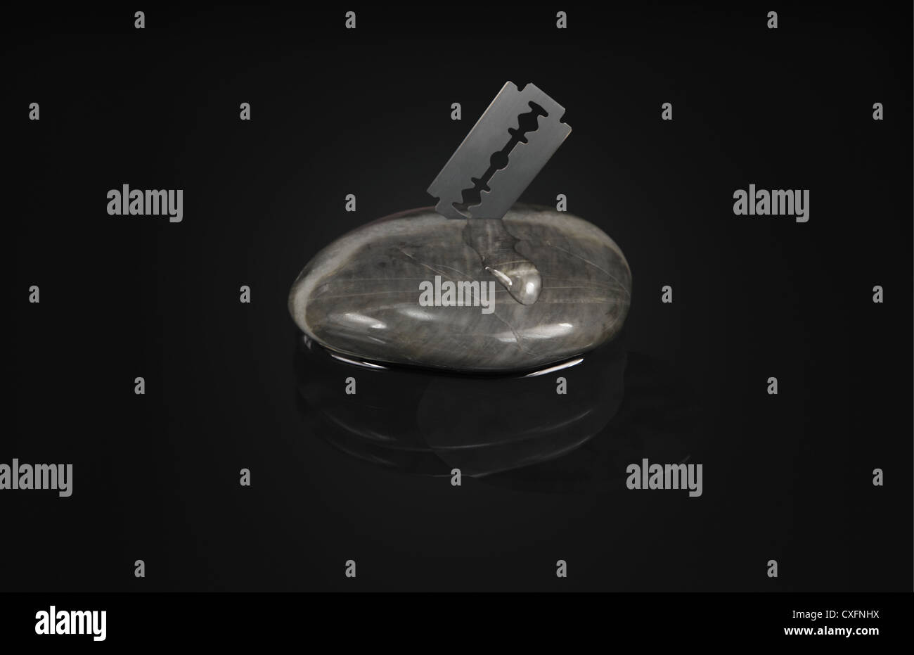 a razor blade makes an incision in a granite stone and out trickles ...