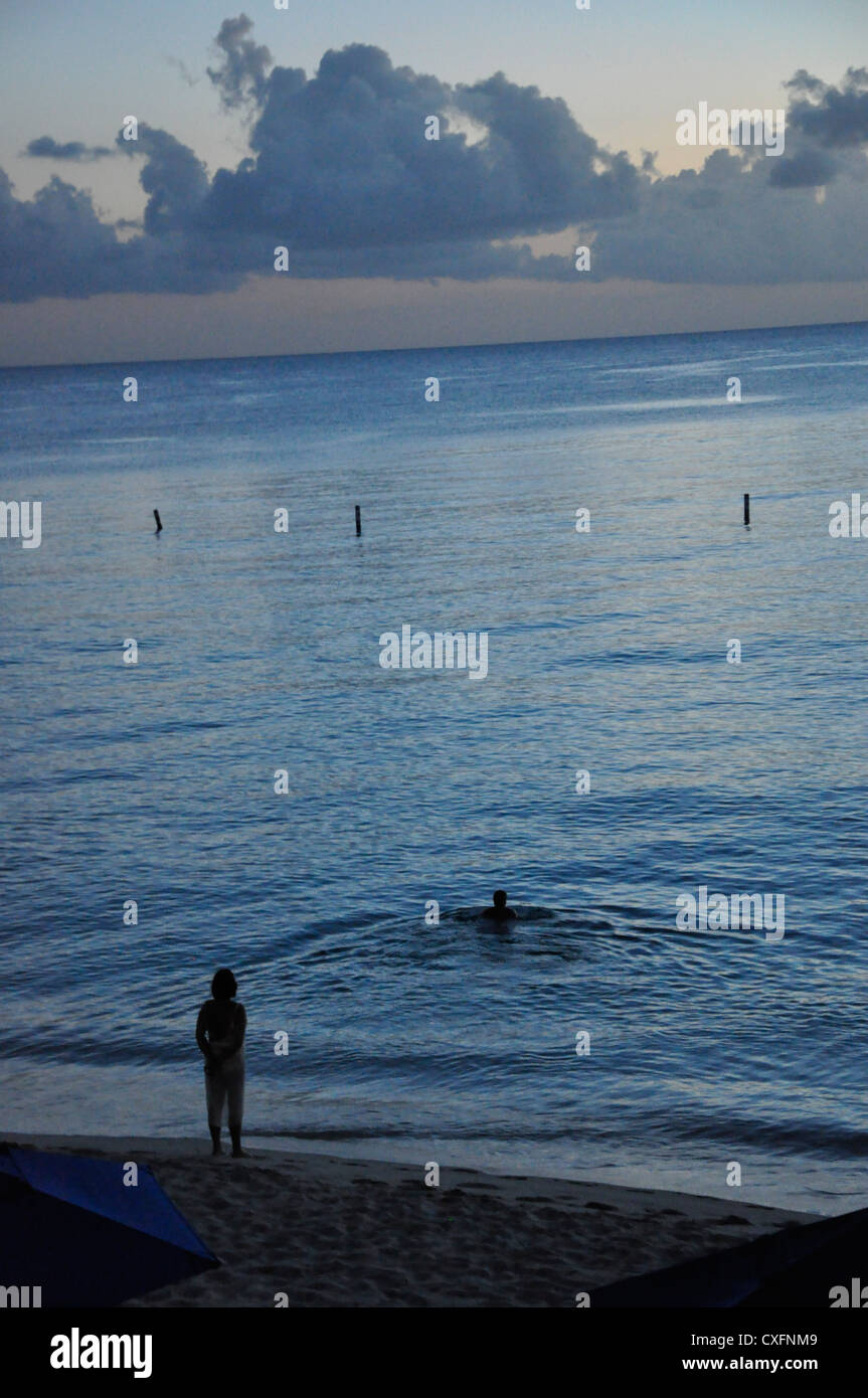 Barbados seascape evening dusk water reflections, swimmers Stock Photo