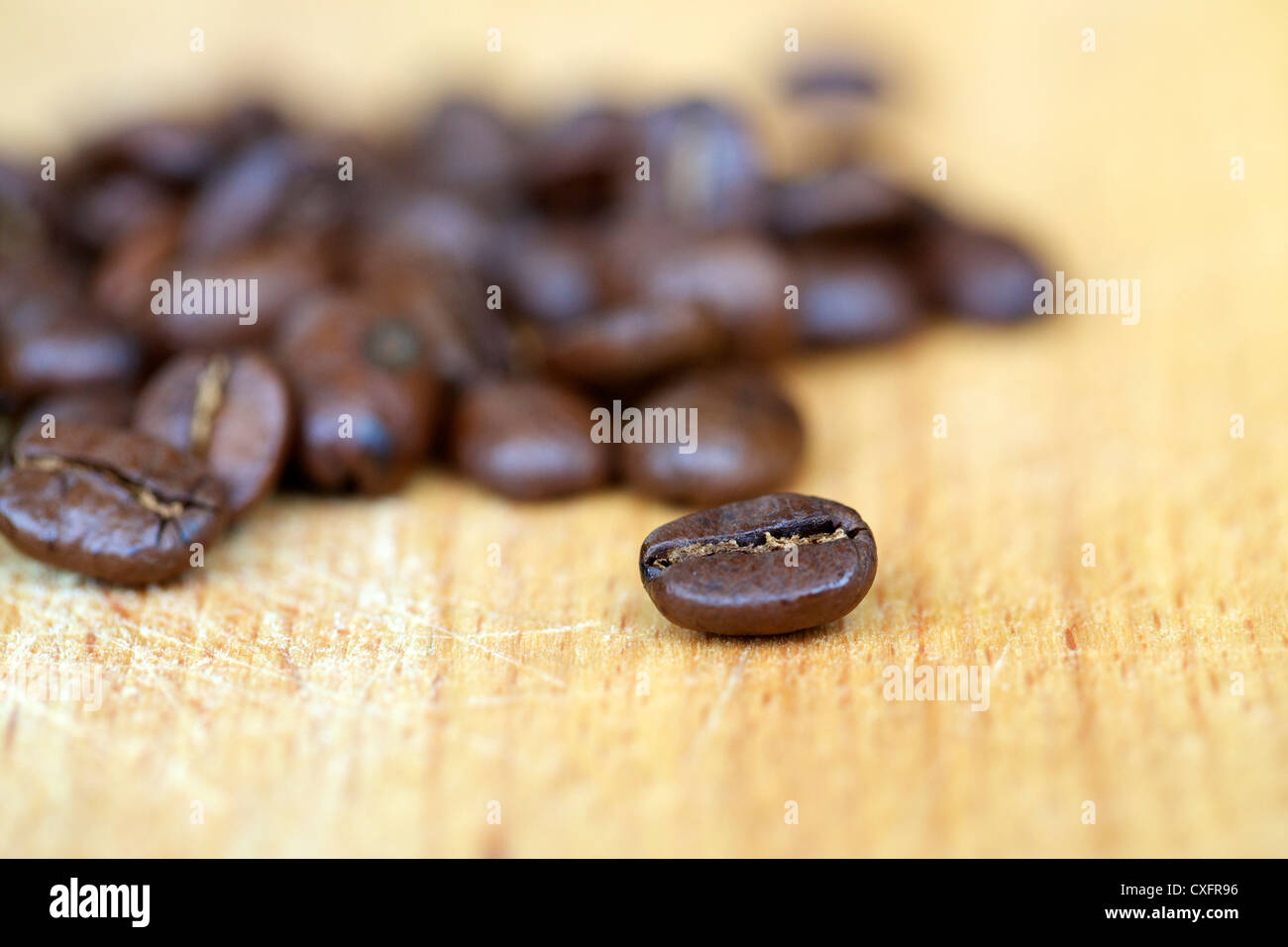 Coffee beans on wooden cutting board. Still life, shallow depth of field. Stock Photo