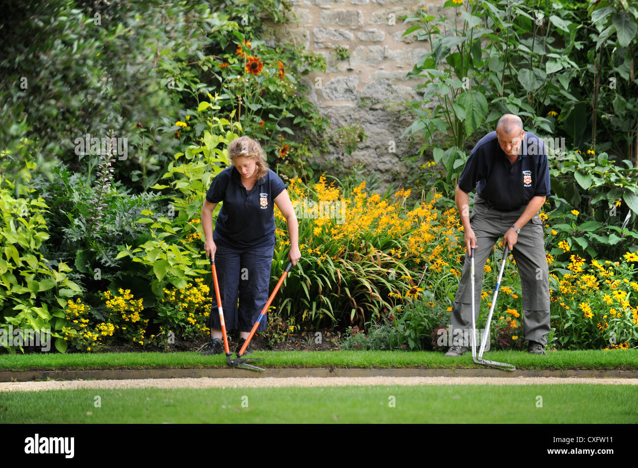 Gardeners with edging shears working along a path at Worcester College Oxford Stock Photo