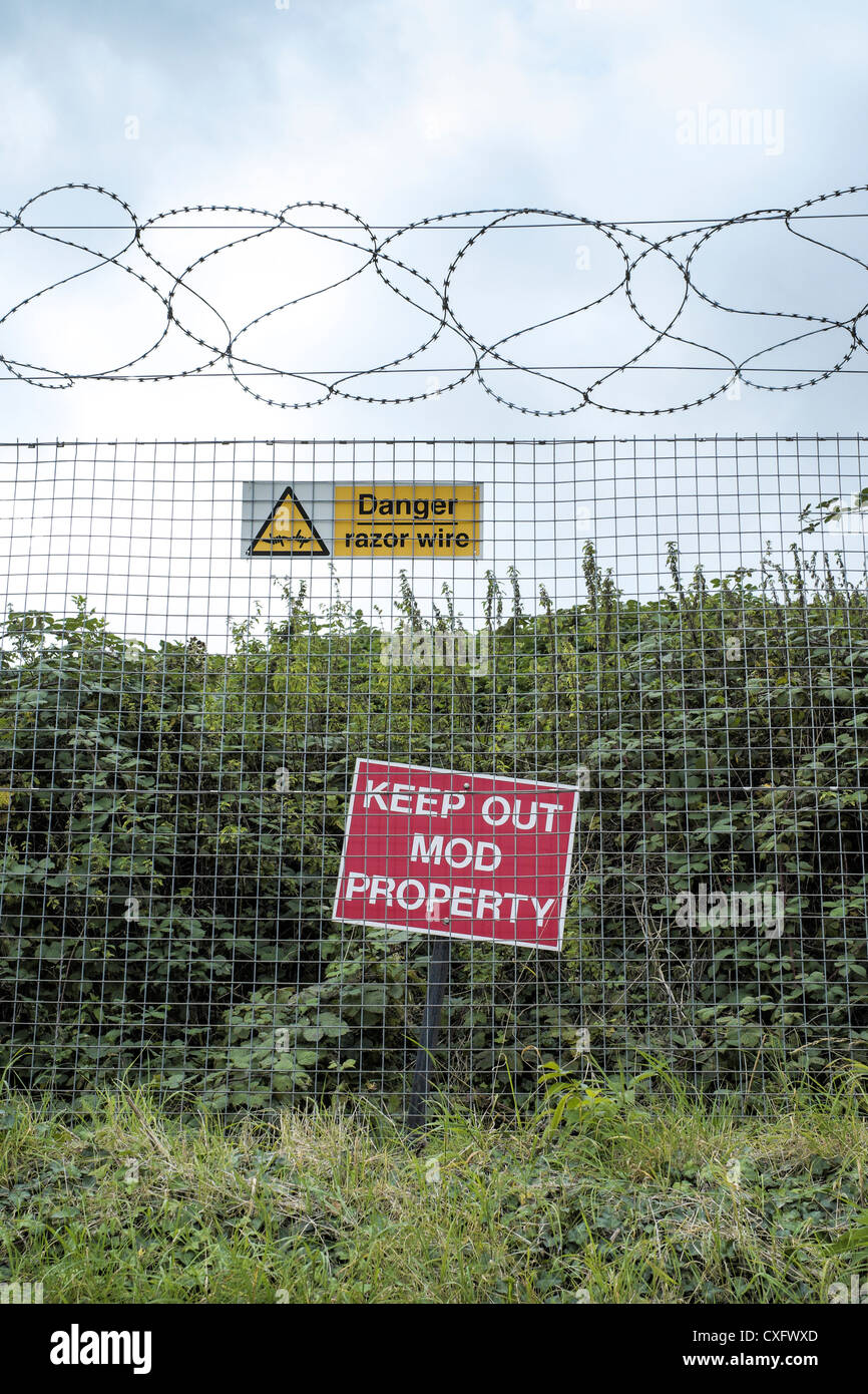 Keep out MOD property sign behind wire fence with razor wire on top Stock Photo
