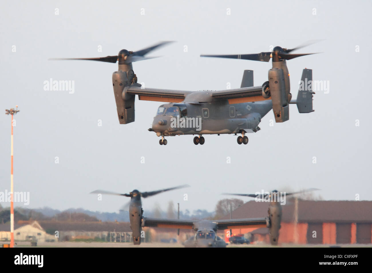 V-22 Osprey lifts from RAF Mildenhall as another taxis to the runway during a short deployment to the base. Stock Photo