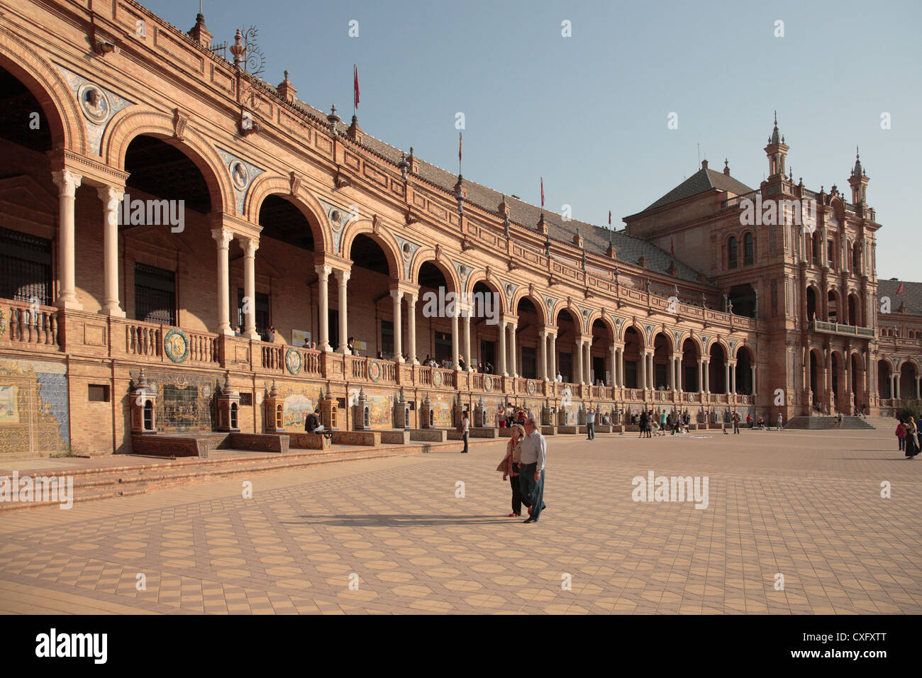 Couple walking in the Plaza de Espana Seville Spain Government buildings overlooking a popular tourist visit. Stock Photo