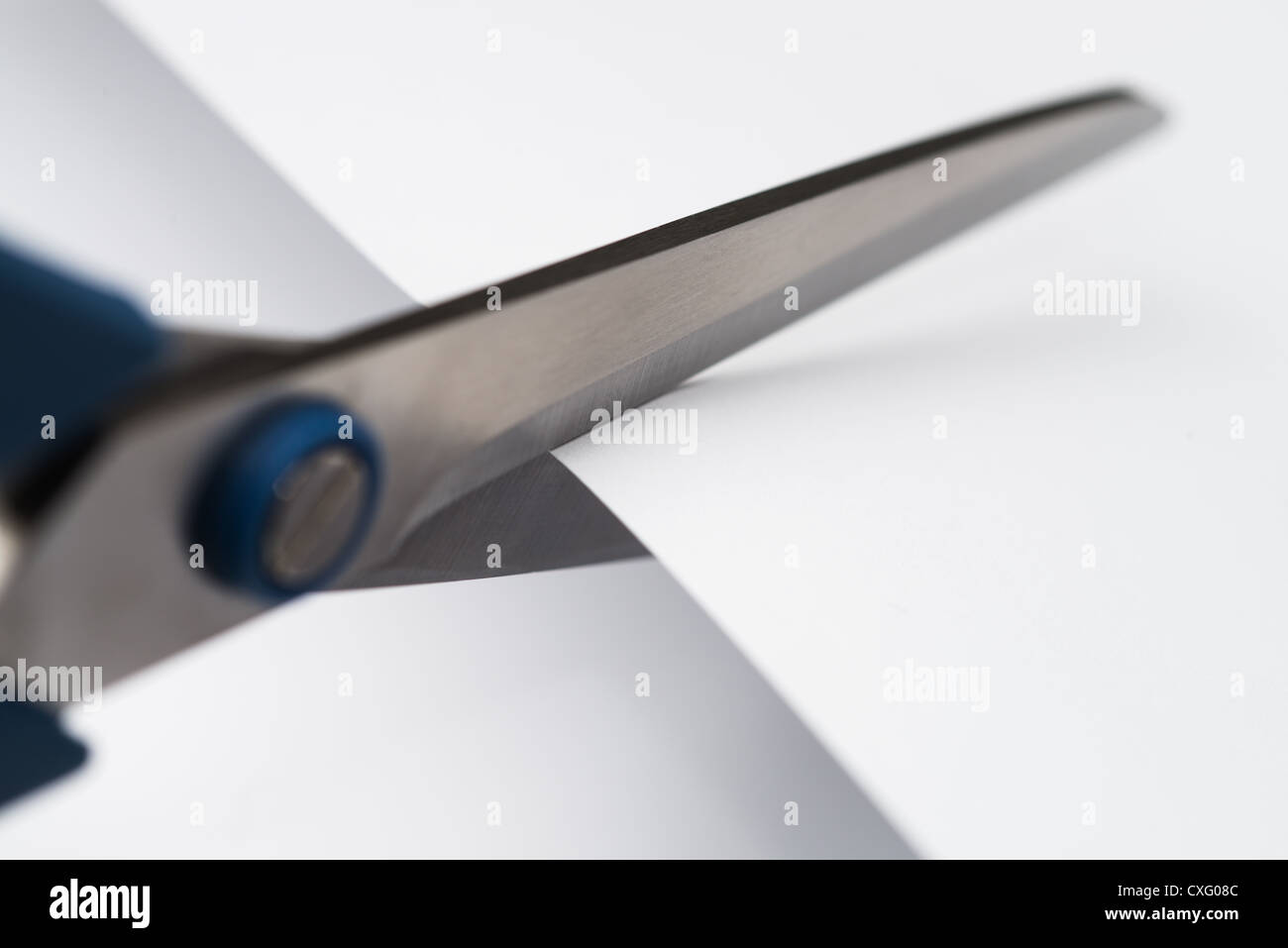 A pair of scissors cutting snipping a piece of paper Stock Photo Alamy