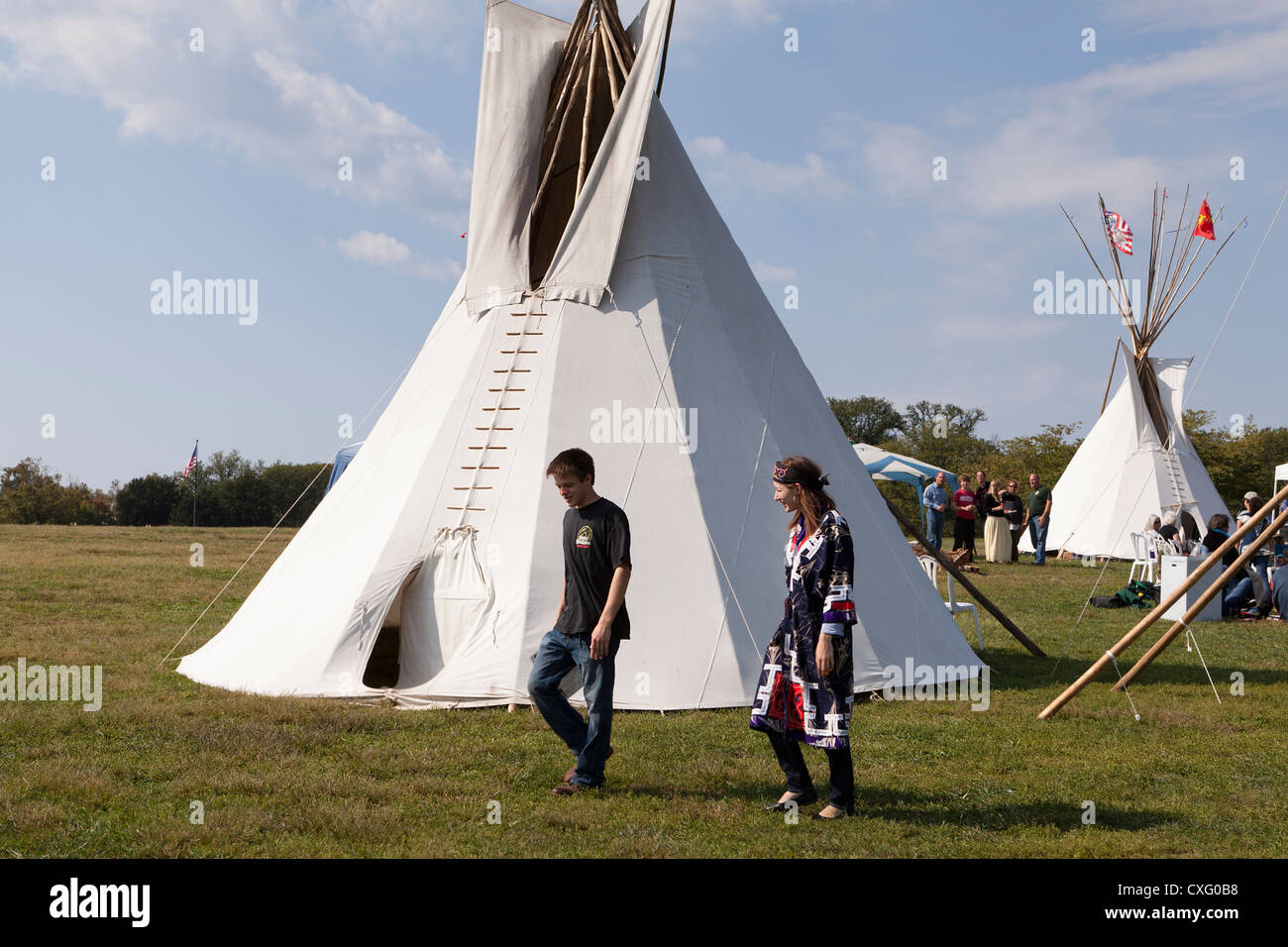 People walking by a tepee Stock Photo