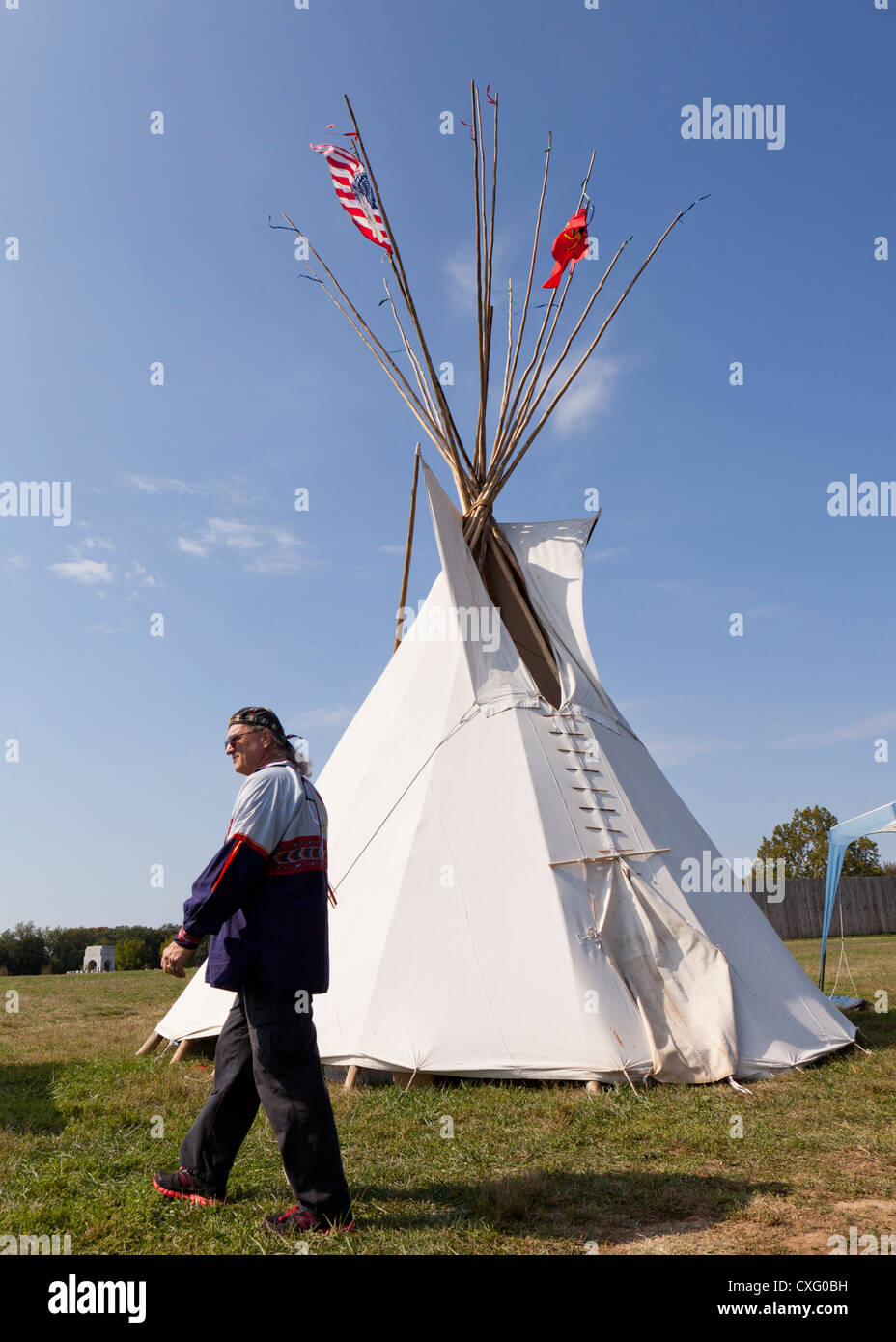 A man walking by a tepee Stock Photo