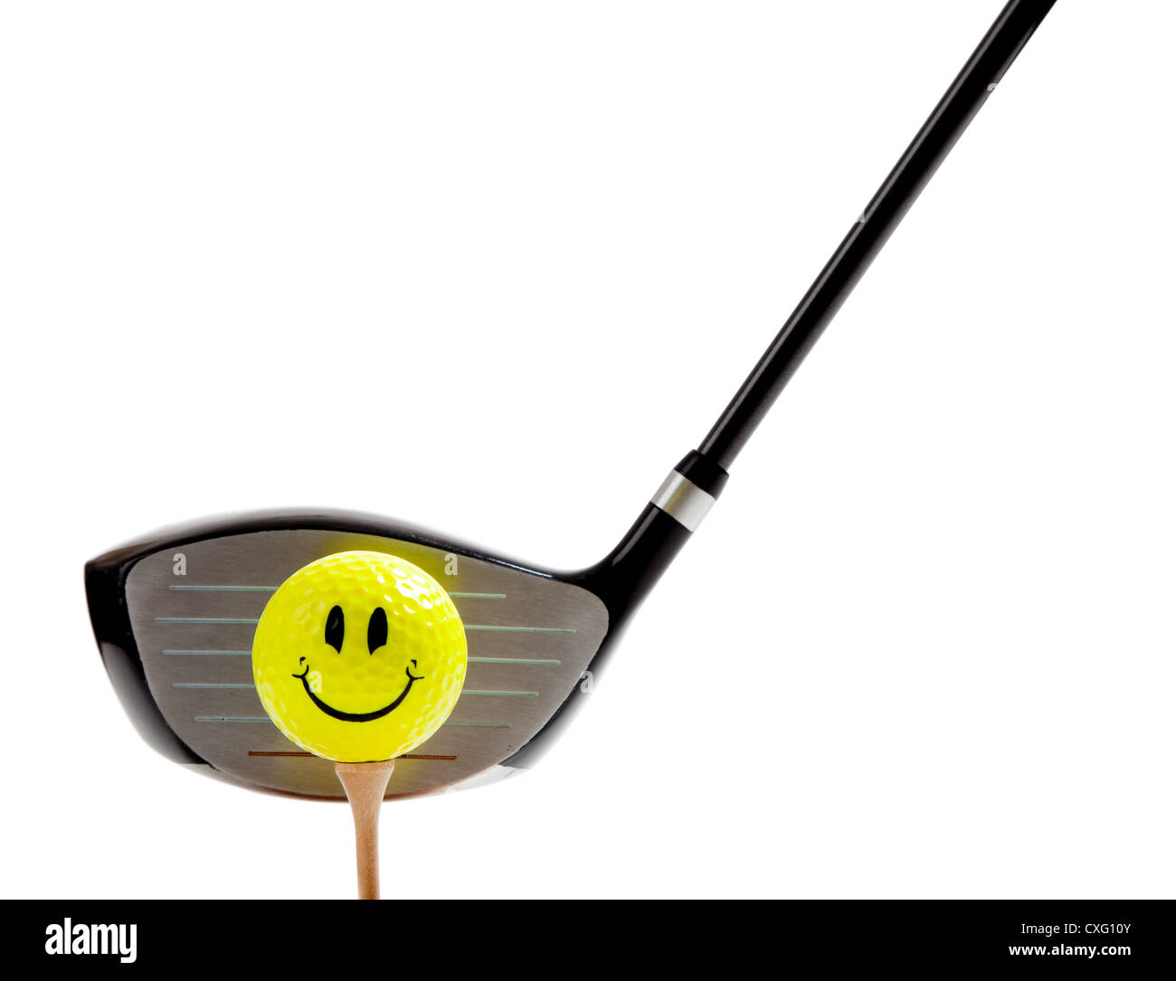 Smiley face on a yellow golf ball with a driver Stock Photo