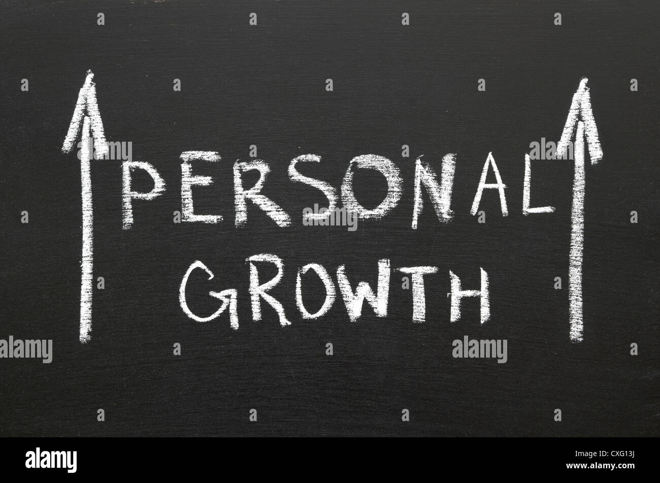 Personal growth phrase handwritten on the chalkboard with rising arrows Stock Photo