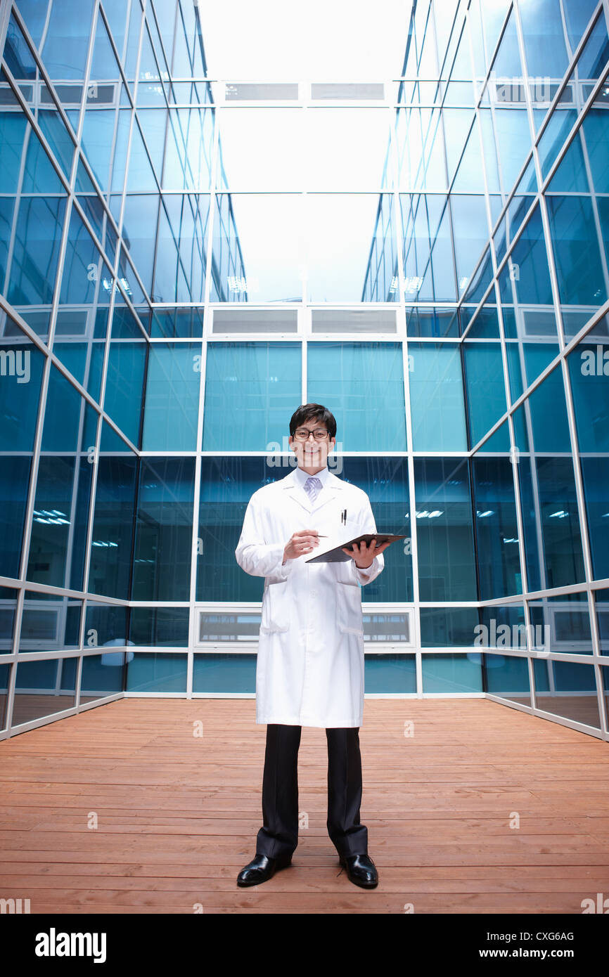 A doctor holding a report standing in middle of a modern building Stock ...