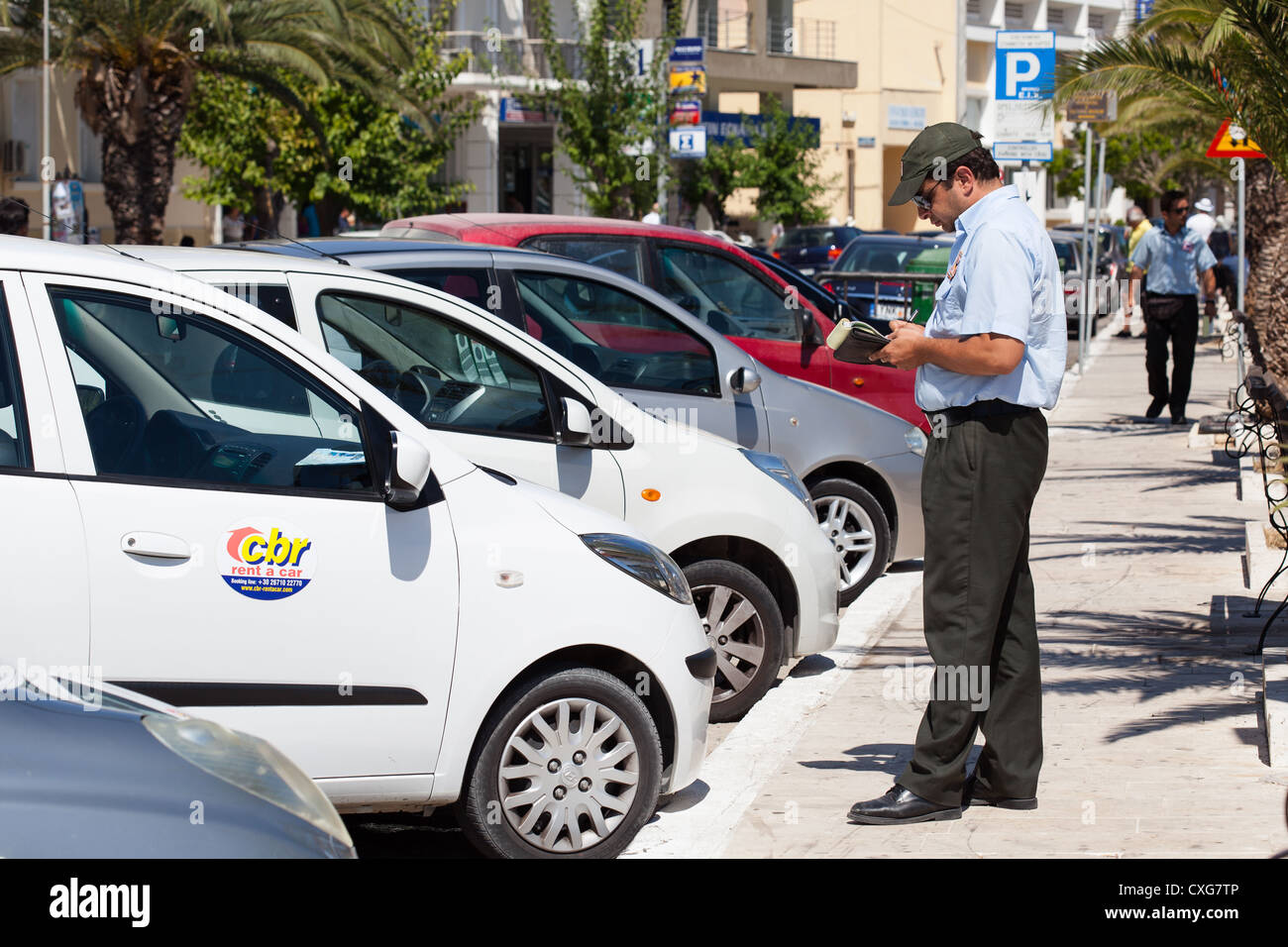 Traffic warden issuing parking ticket to 'Rental Car'. Argostoli Cephalonia Greece Stock Photo