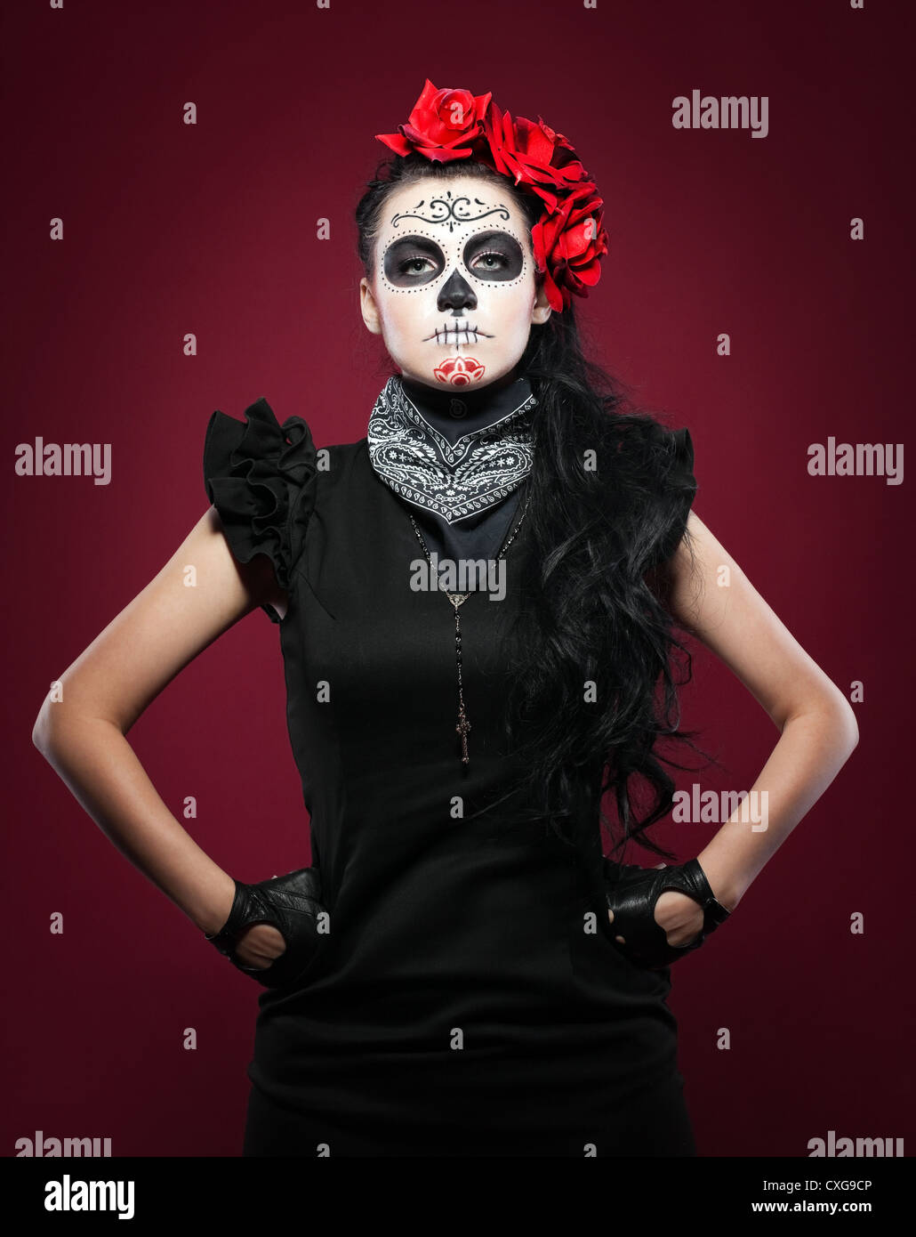 Young girl in day of the dead mask on red Stock Photo