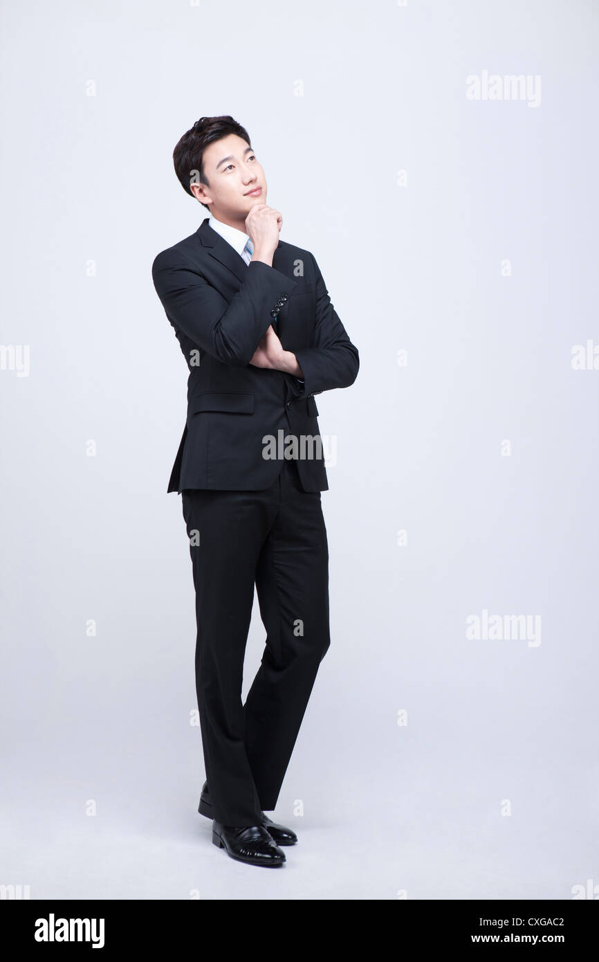 man standing and resting his chin on his hand Stock Photo Alamy
