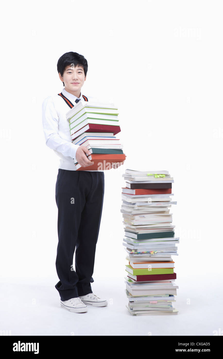 schoolboy holding books next to a stack of books Stock Photo - Alamy