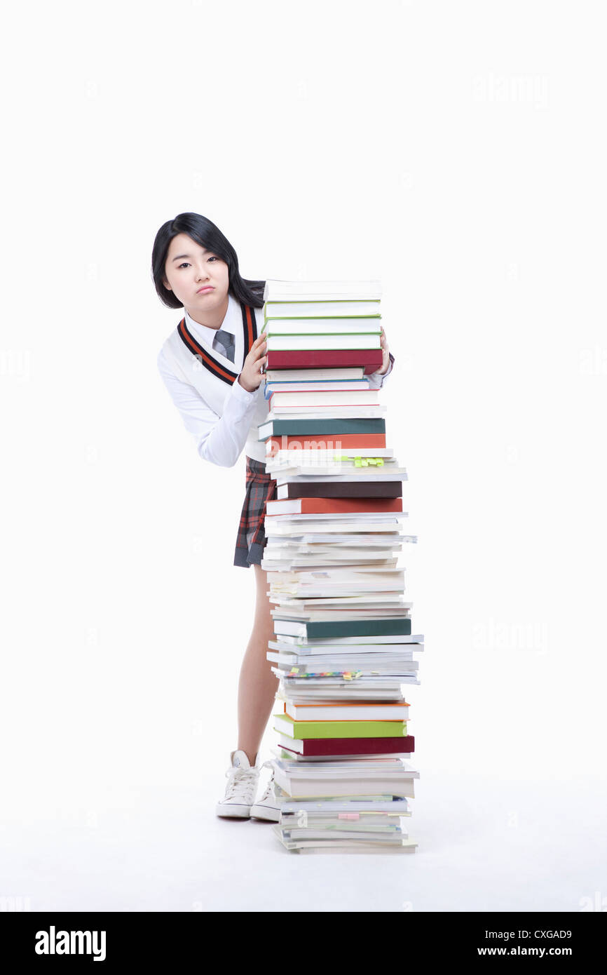 schoolgirl standing behind a stack of books Stock Photo - Alamy