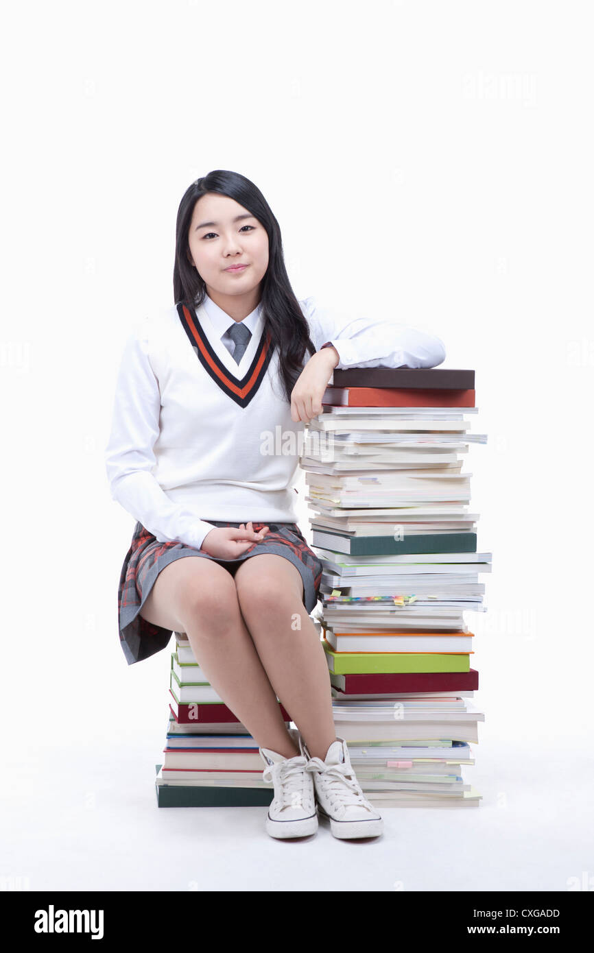 schoolgirl sitting on a stack of books Stock Photo - Alamy