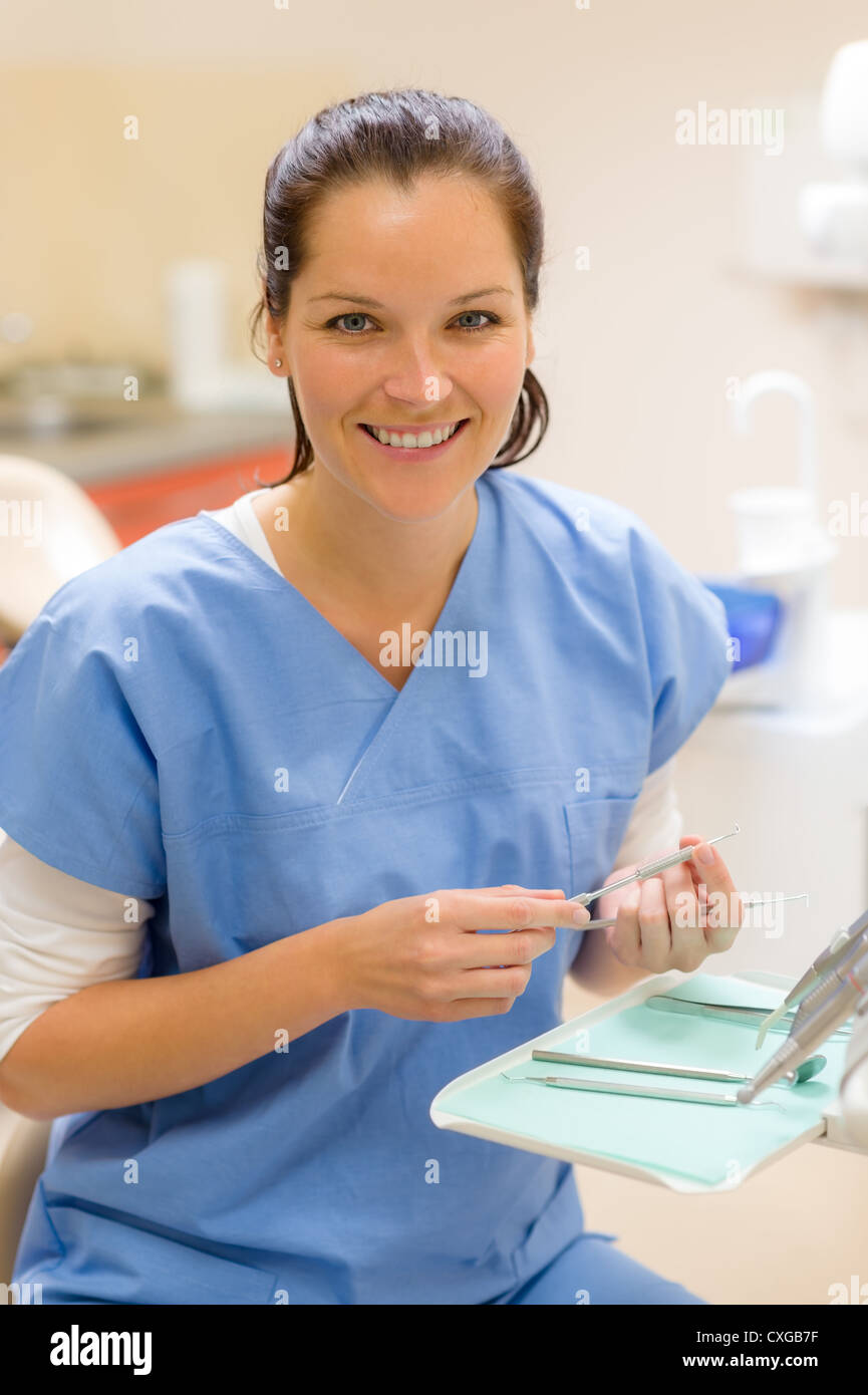 Female dentist with dental equipment at surgery smiling friendly staff