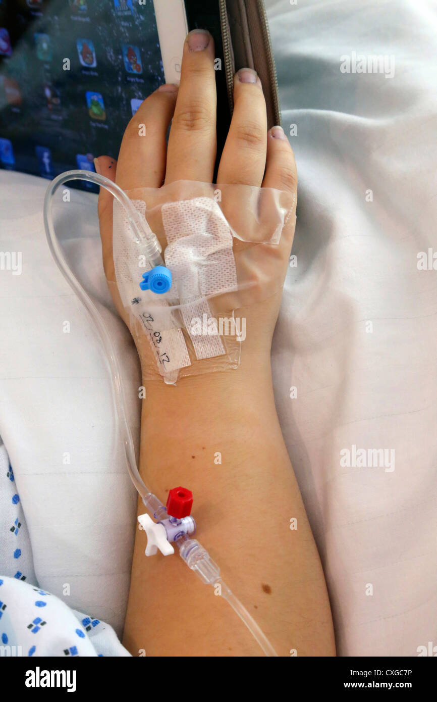 Patient With Cannula In Hospital Bed Working On iPad Ashtead Surrey England Stock Photo