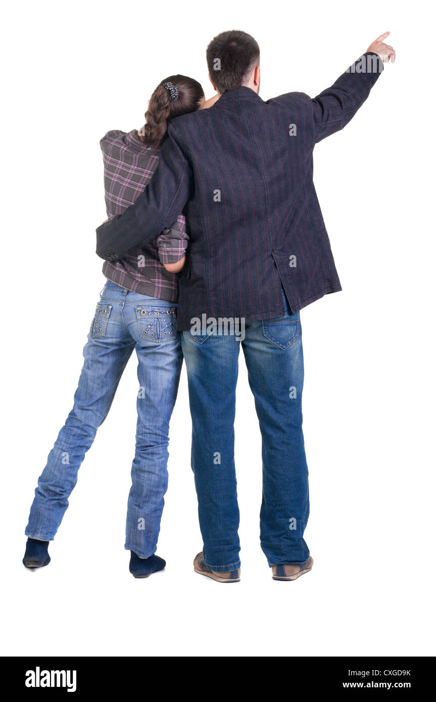 Young couple pointing at wall. Rear view. Isolated over white background. Stock Photo
