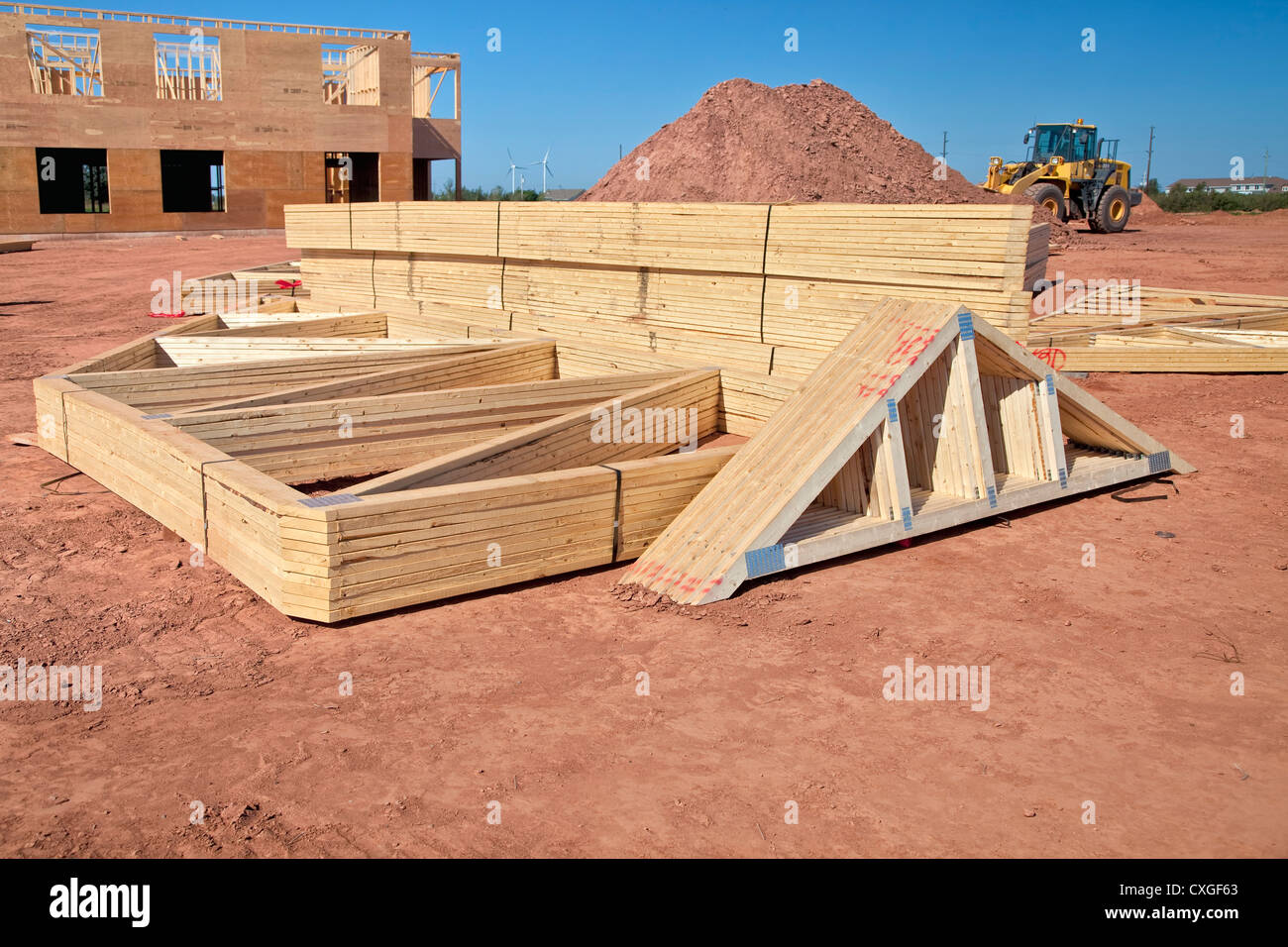 Roof rafters stacked up on a construction site for a large building and waiting for installation. Stock Photo