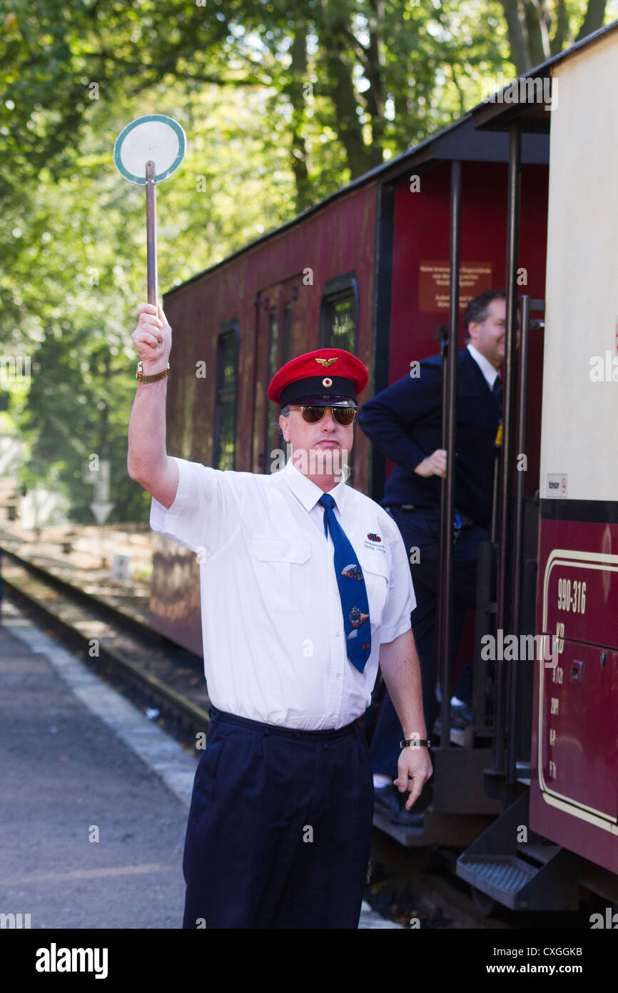 The Molli bahn at Bad Doberan - Germany.  The guard giving the green signal to leave Stock Photo