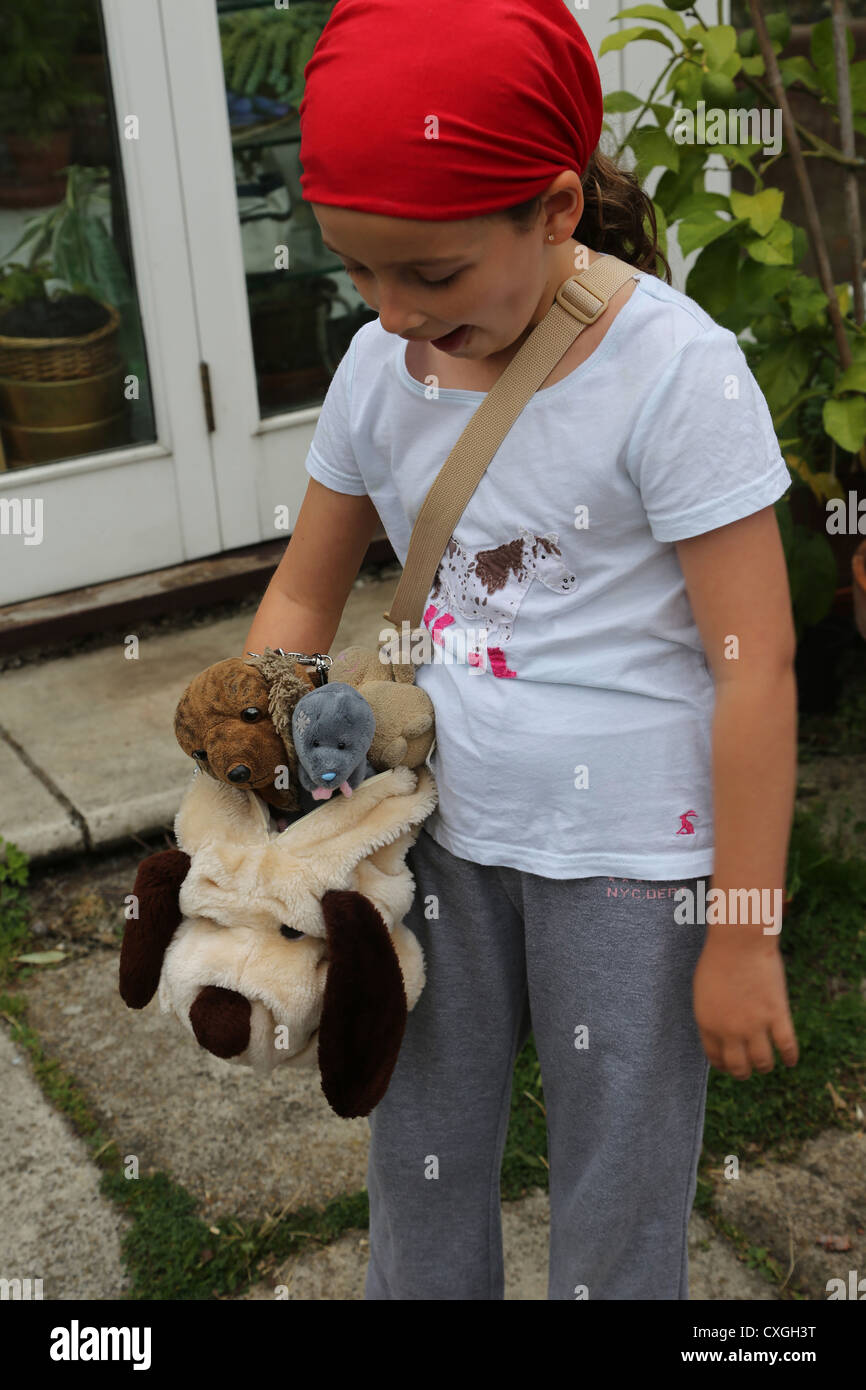 Girl With Soft Toys In Dog Bag England Stock Photo