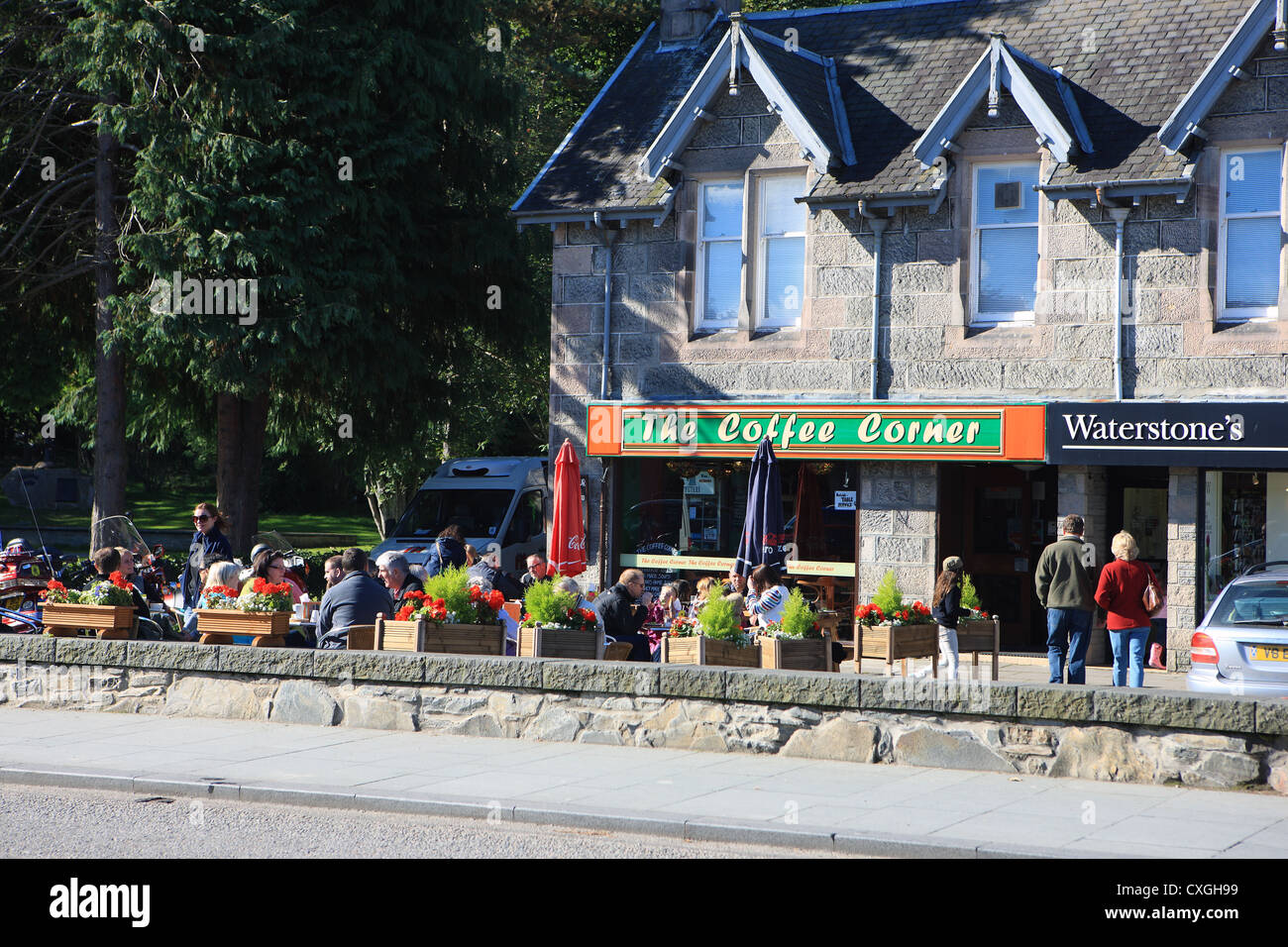 Aviemore - People sitting in the autumn sunshine outside a cafe in Aviemore in the Scottish Highlands Stock Photo