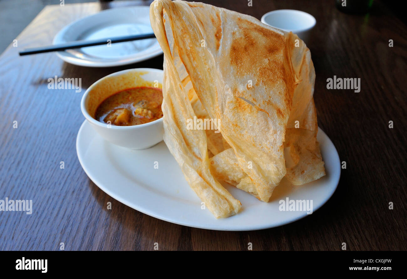 Roti canai, Indonesian and Malaysian, a pancake with curry dipping  sauce Stock Photo