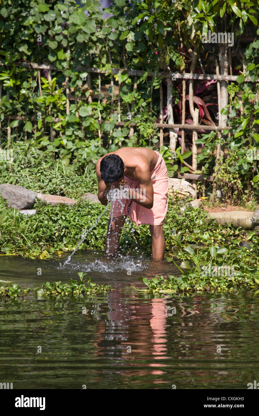 Washing in the backwaters of Alleppey, Kerala, India. Stock Photo