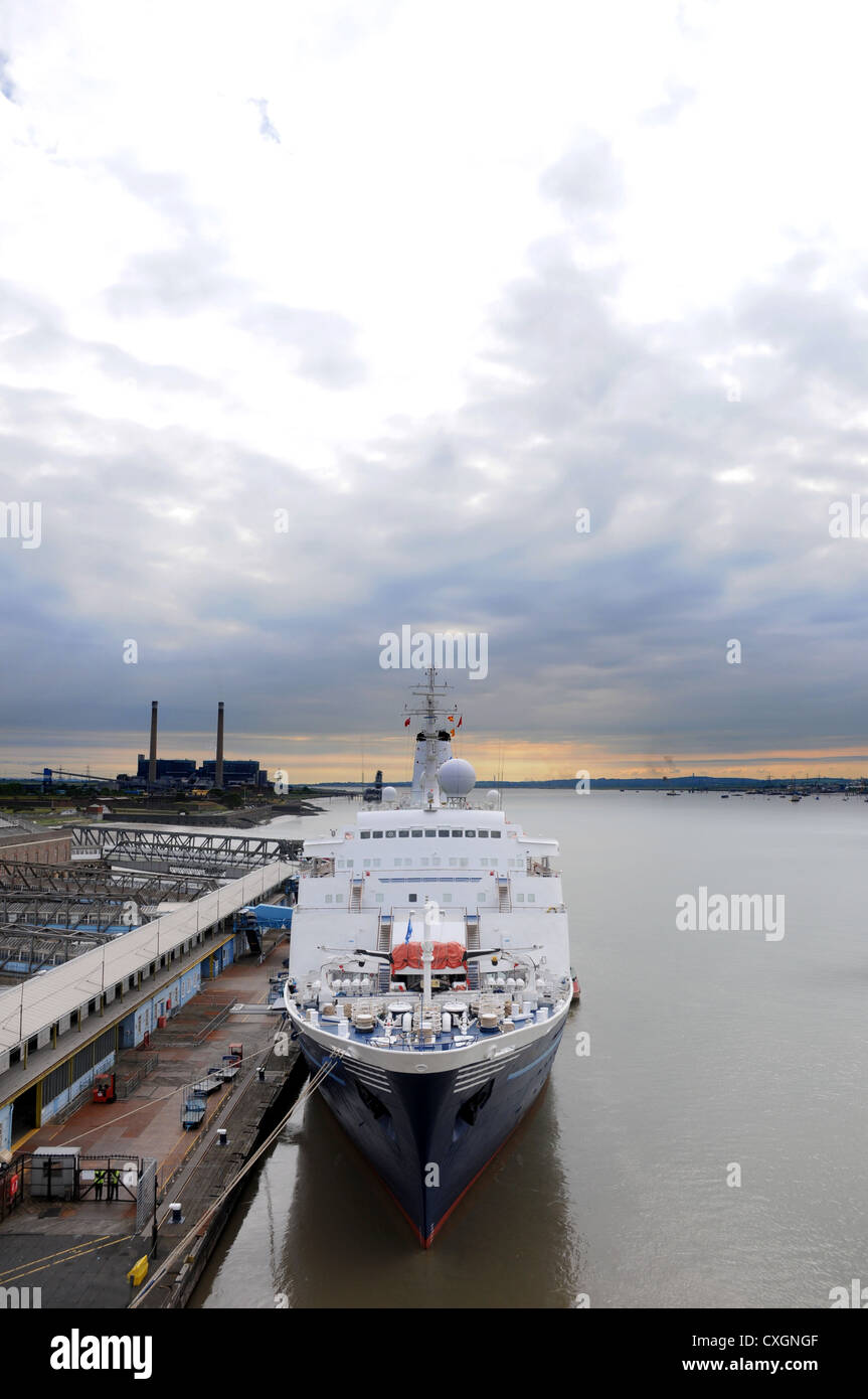 Seen from the from high up an ocean going cruise liner bearthed up at a dock with morning sky clouds Stock Photo