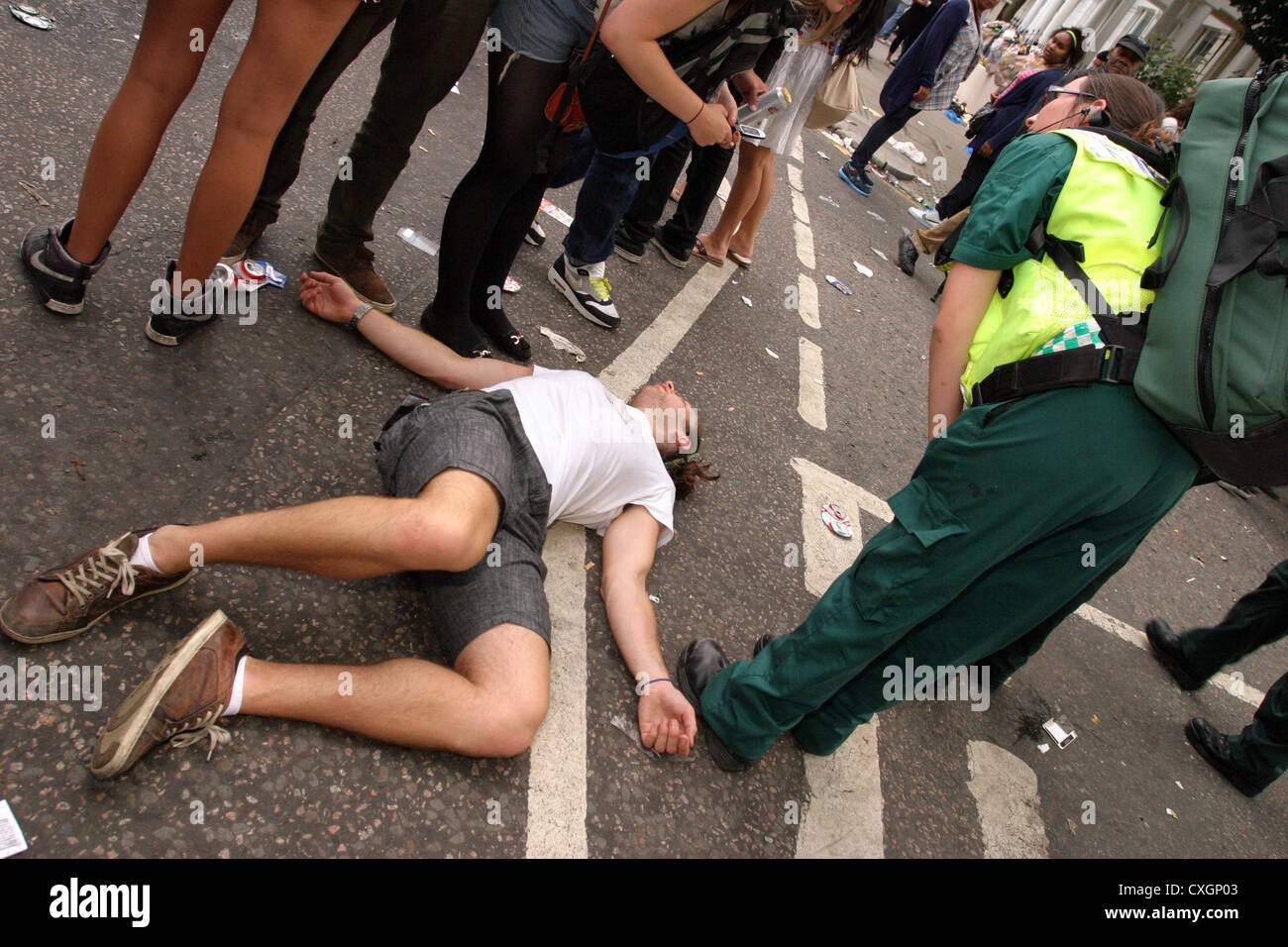 Youth collapsed in a crowded  street Stock Photo