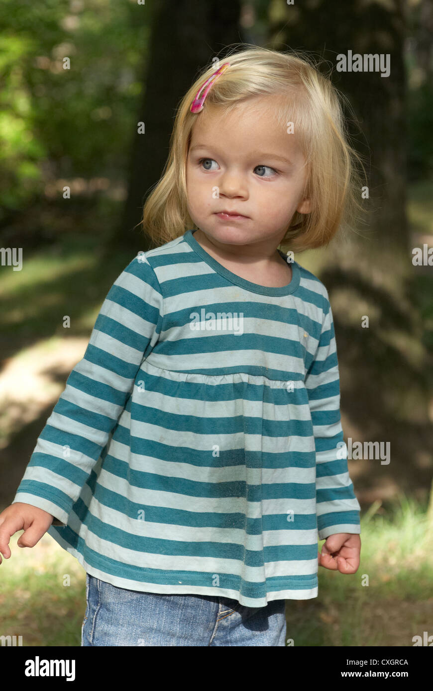 Adorable Blue Eyed Girl Playing Outside in the summer forest Stock
