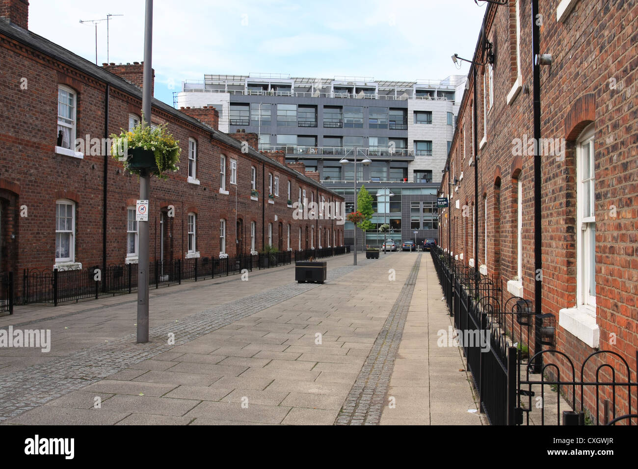 A street of terraced houses in Manchester with a new office development