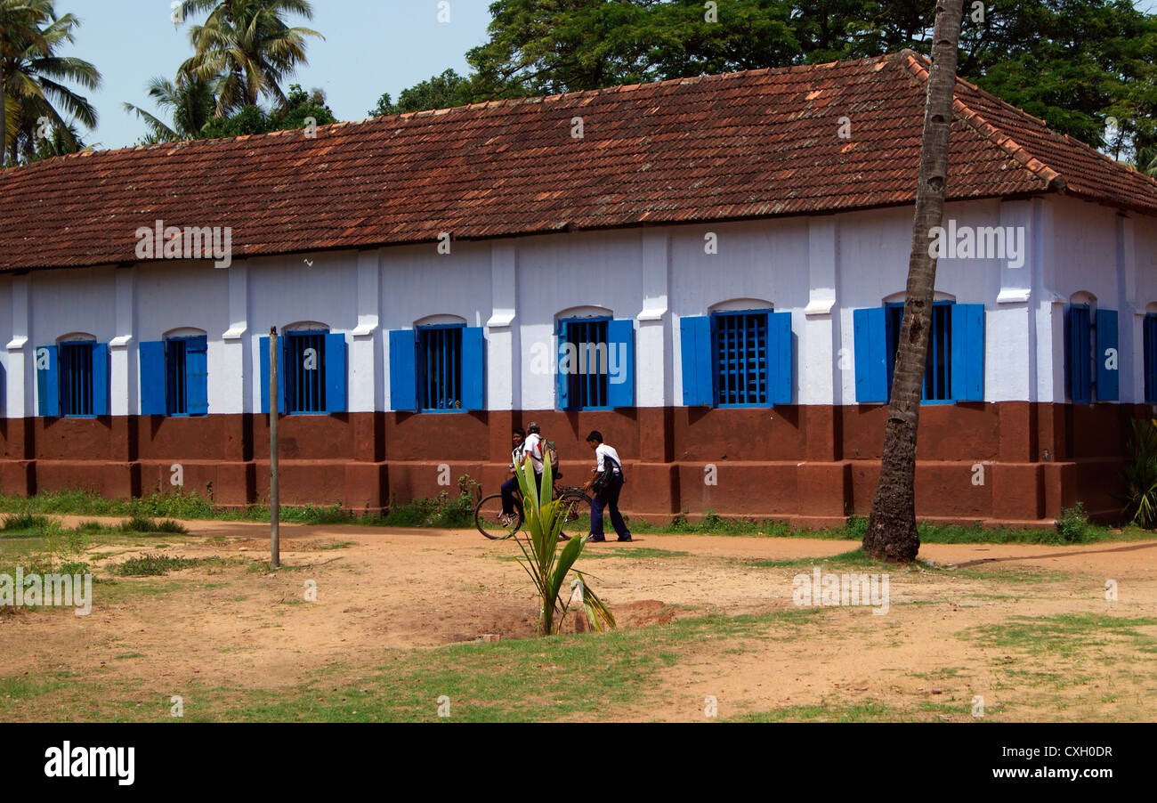 School Going Children Riding cycle near School Building.Scene from Old Government School Compound at Kerala India Stock Photo