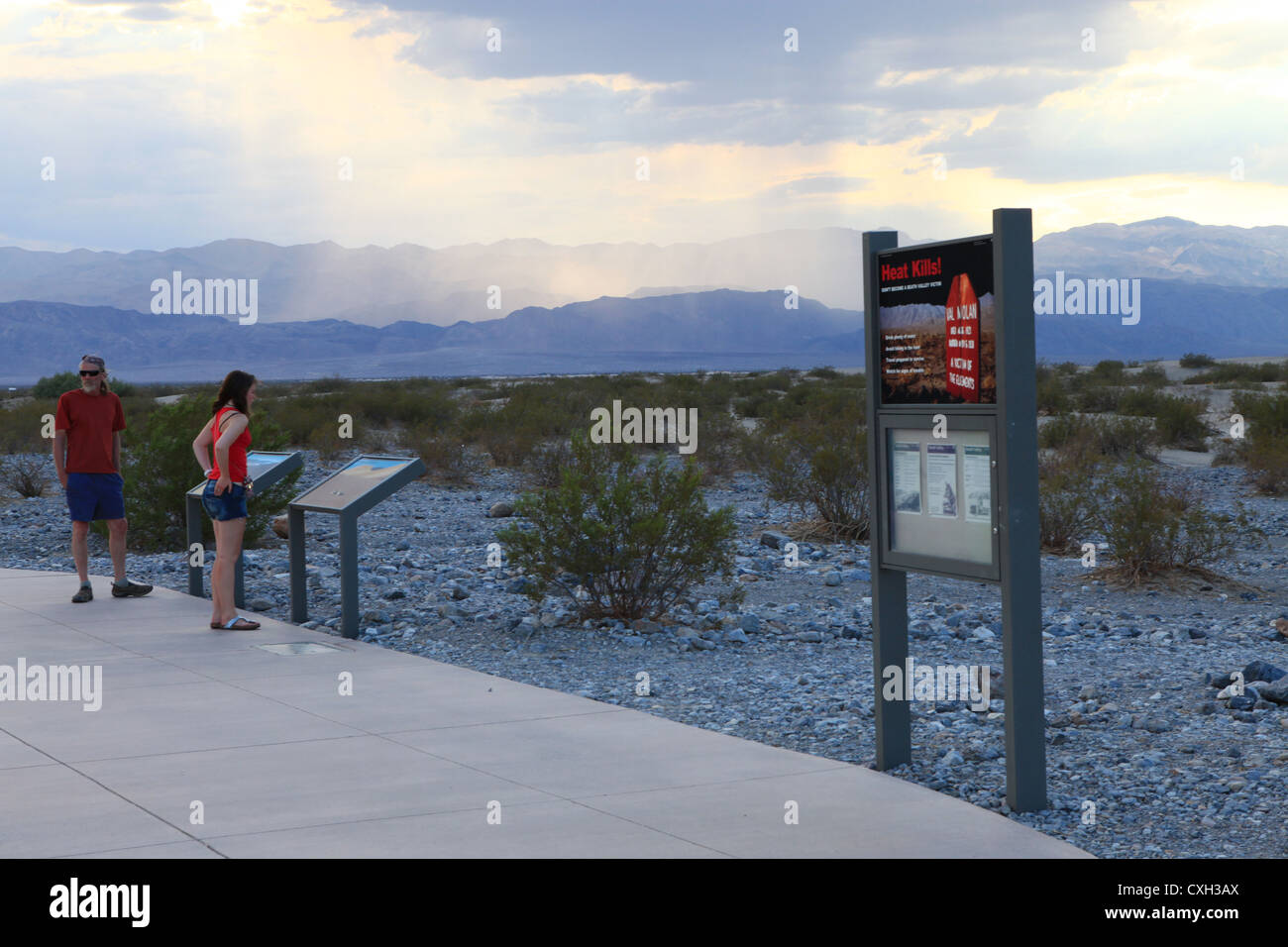 Travellers looking at map and warning sign in Death Valley national park desert in Nevada, US Stock Photo