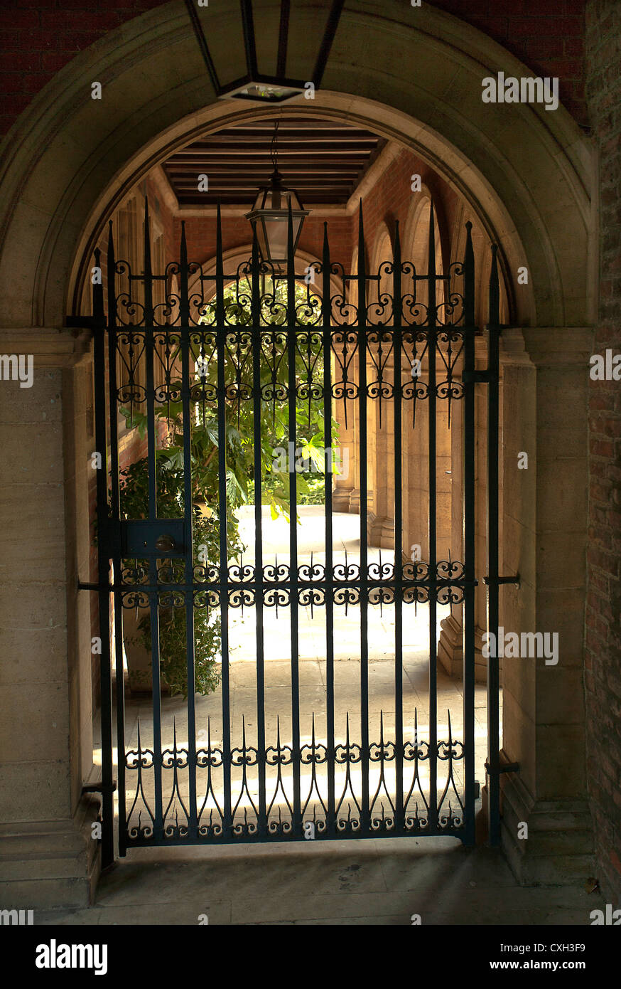 A wrought iron gate leading from a passage to a garden Stock Photo - Alamy