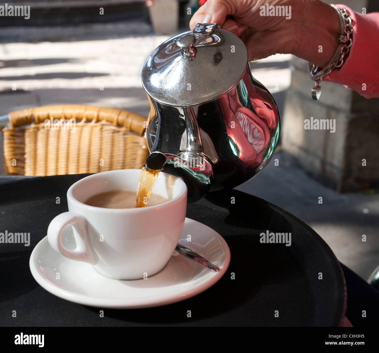 Pouring a cup of tea from a teapot Stock Photo Alamy