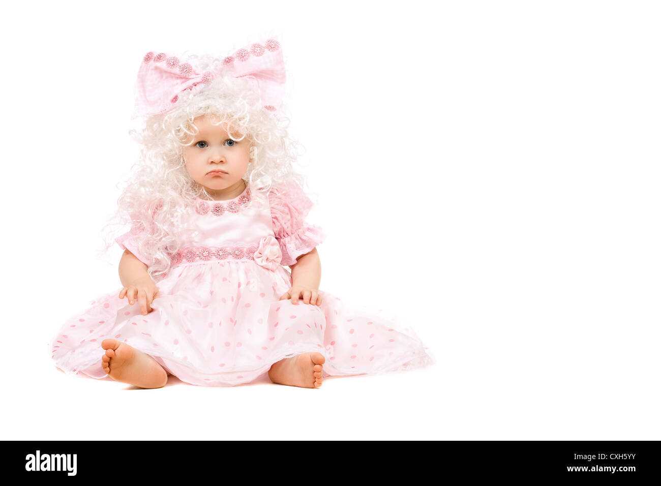 Sad baby girl in a pink dress Stock Photo