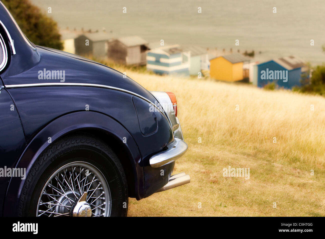 Jaguar Mk II, parked on grass at top of Tankerton slopes, Whitstable, Kent, England, UK with beach huts and sea in background Stock Photo