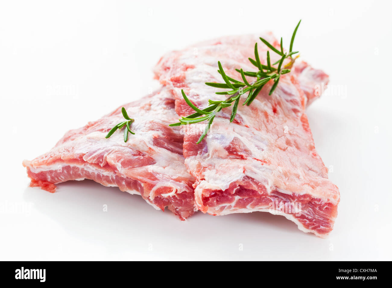 Raw spare ribs with rosemary on white background Stock Photo