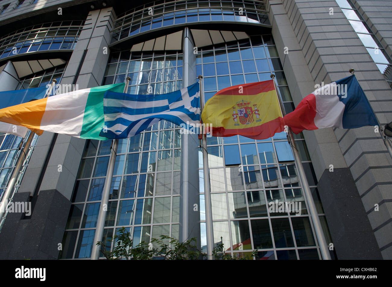 Flags of Italy, Greece, Spain and France outside European Parliament building in Brussels Stock Photo