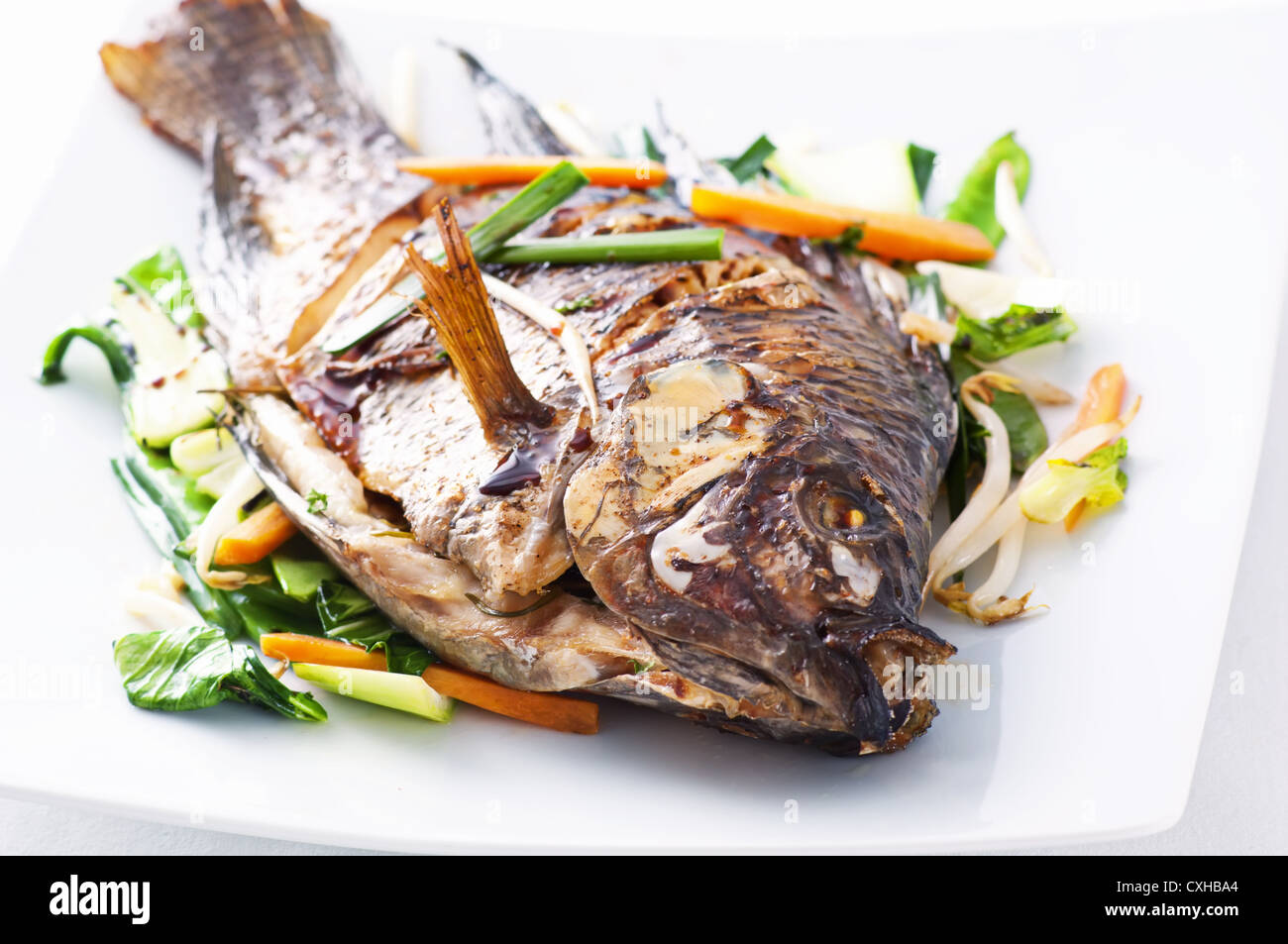 Tilapia fried with asian vegetables Stock Photo
