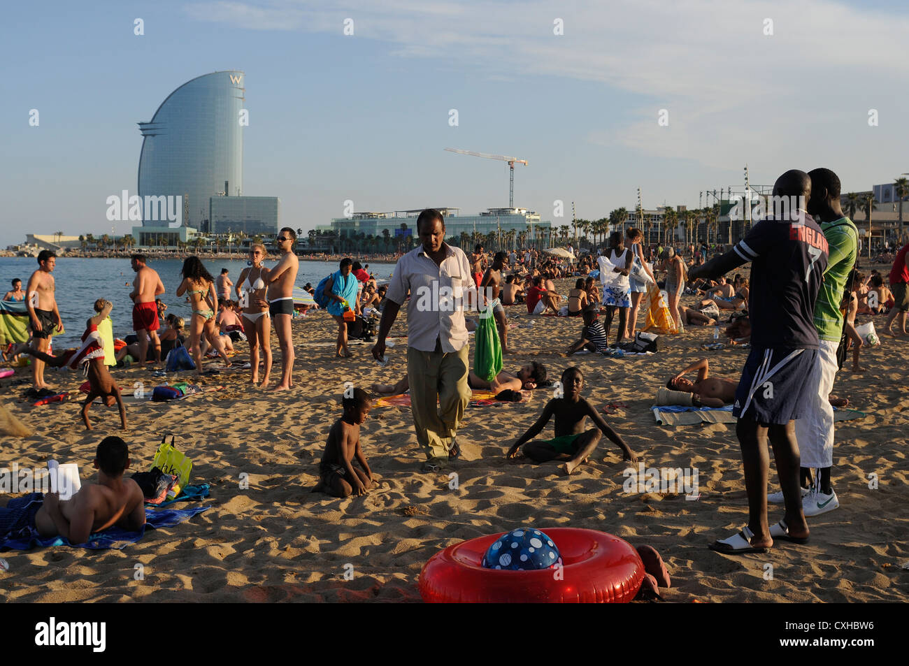 crowded beach with illegal ambulant sellers  of can of beers inside the green bags Stock Photo