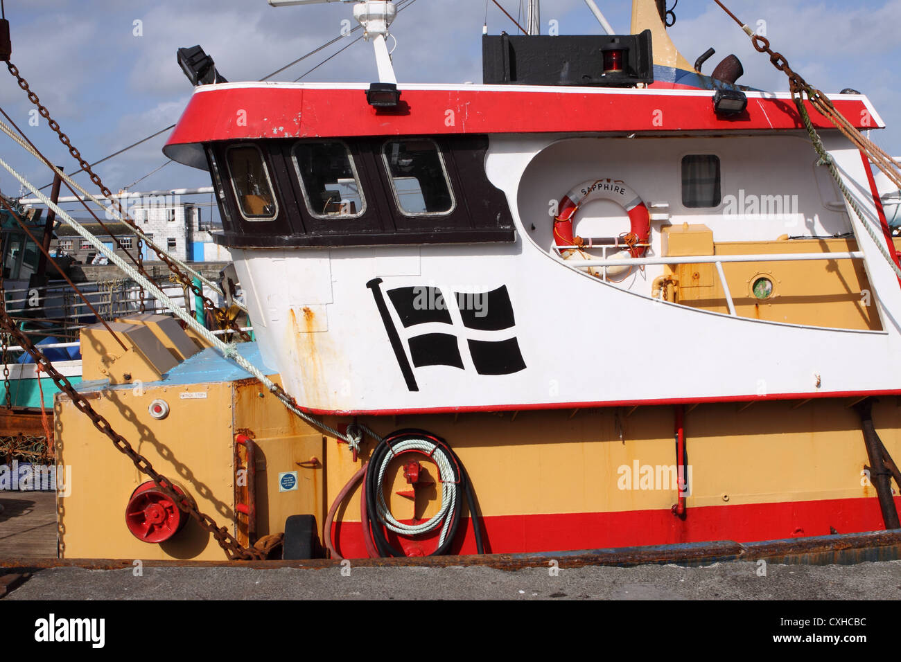 Newlyn harbour Cornwall local fishing boat with Cornish flag painted on the cabhouse Stock Photo