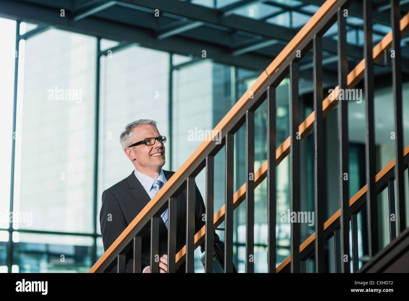 Germany, Stuttgart, Businessman moving up on office staircase Stock Photo
