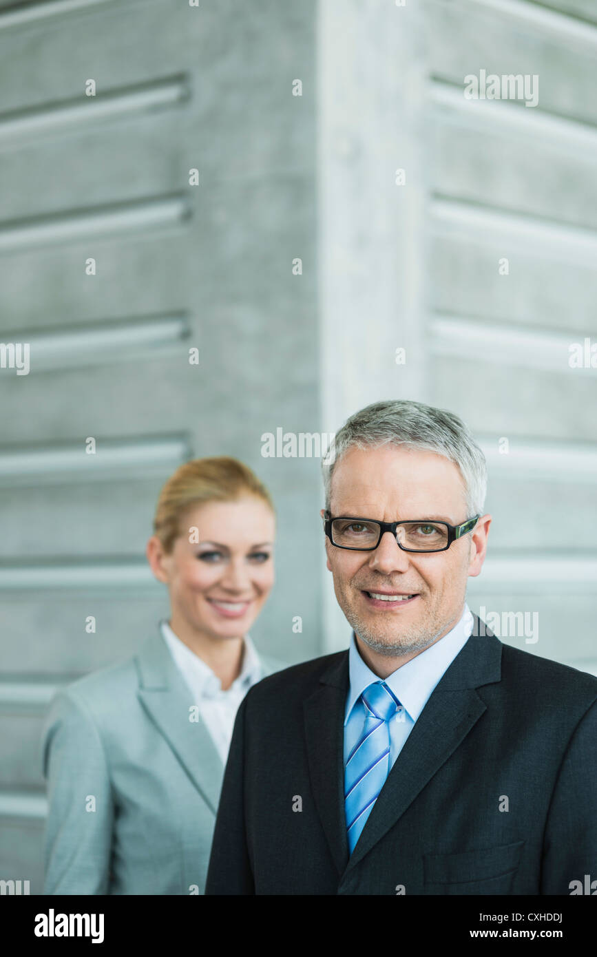 Germany, Stuttgart, Business people in office lobby, smiling, portrait Stock Photo